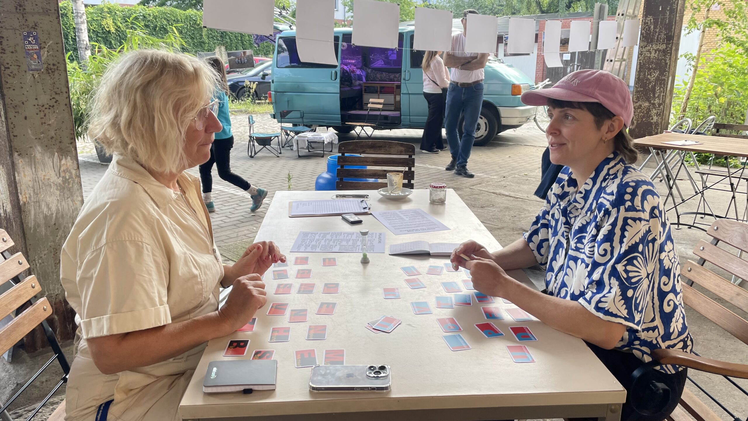 Besucherinnen der Ausstellung 48h Neukölln, Juli 2025, spielen das Spiel um Demokratie.